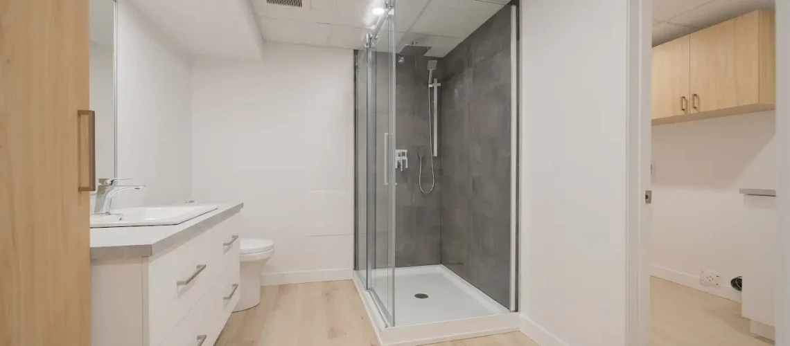 Salle de bain moderne avec une baignoire autoportante, un meuble-lavabo sur mesure et un éclairage doux.