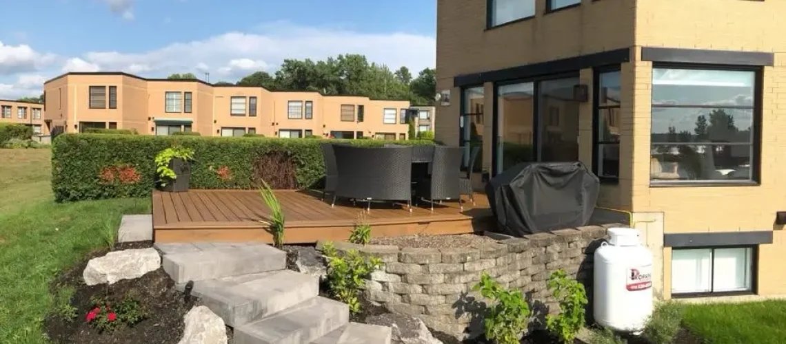 Patio en bois traité avec un mobilier confortable et un éclairage doux, parfait pour les soirées d'été.