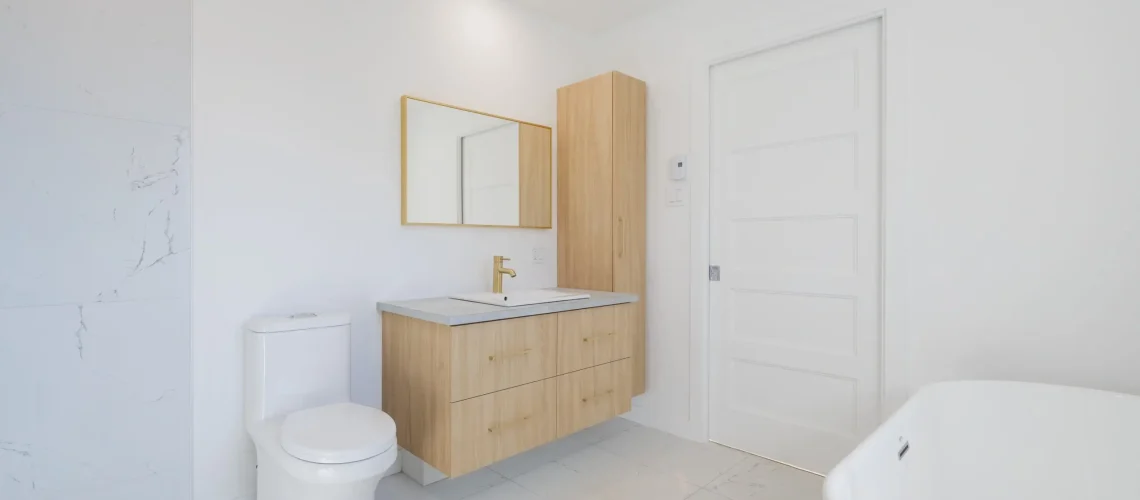 Salle de bain minimaliste avec des lignes nettes, des couleurs sobres et un éclairage moderne.