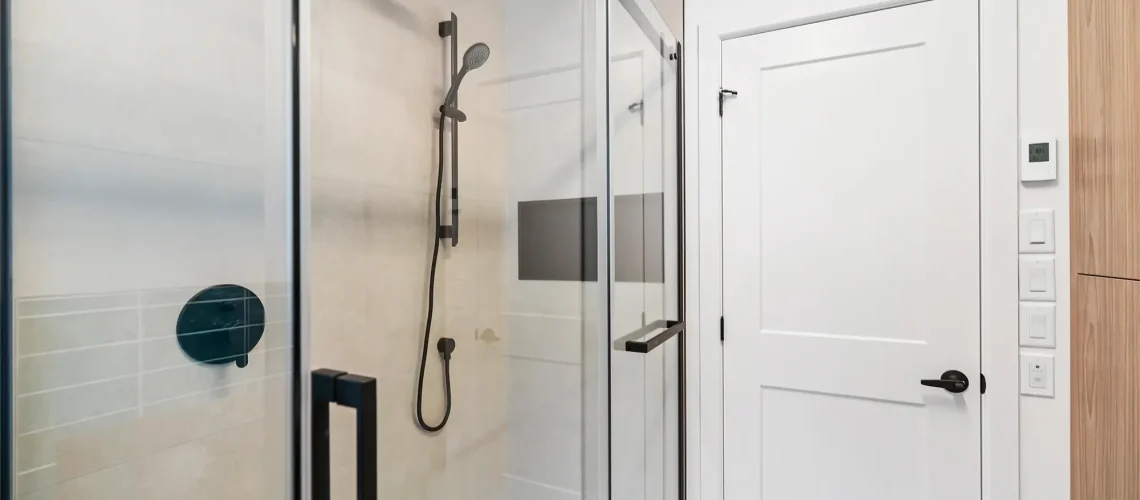 Salle de bain rénovée avec une grande douche à l'italienne, un lavabo double et des armoires fonctionnelles.